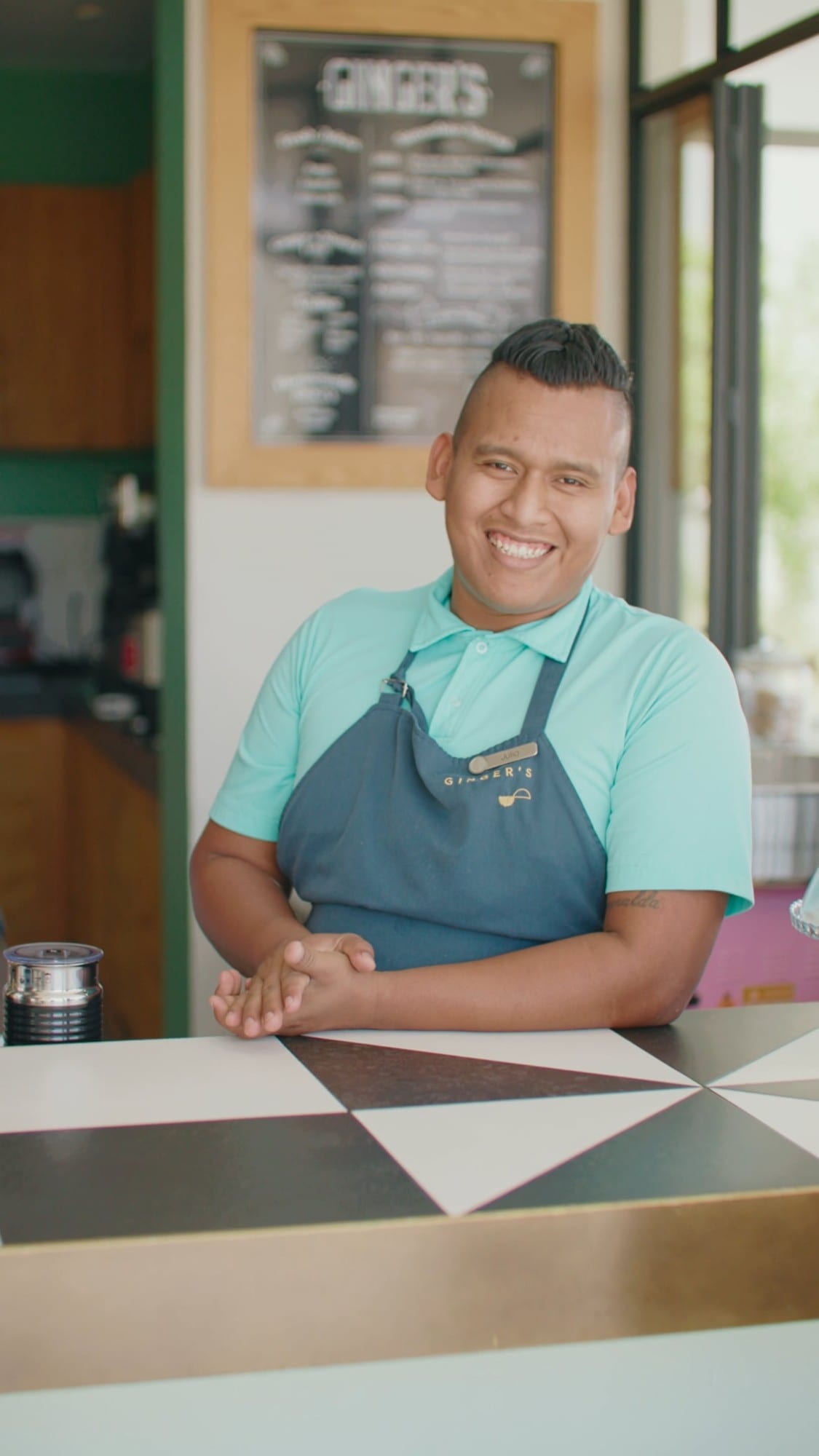 A smiling staff member behind the counter